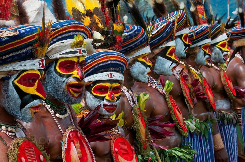 Members of a tribe in colourfully decorated costumes with face paint at the traditional sing-sing gathering