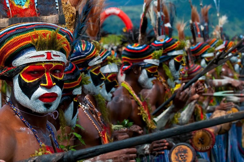 Members of a tribe in colourfully decorated costumes with face paint at the traditional sing-sing gathering