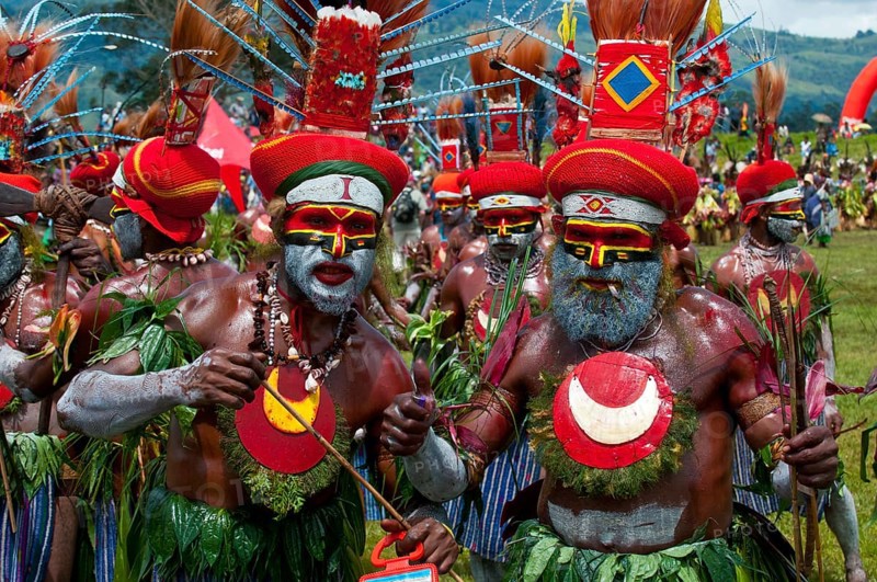 Members of a tribe in colourfully decorated costumes with face paint at the traditional sing-sing gathering