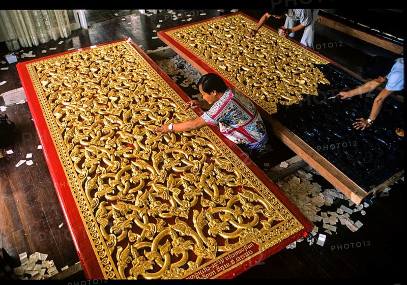 Craftsmen gilding doors with gold leaf