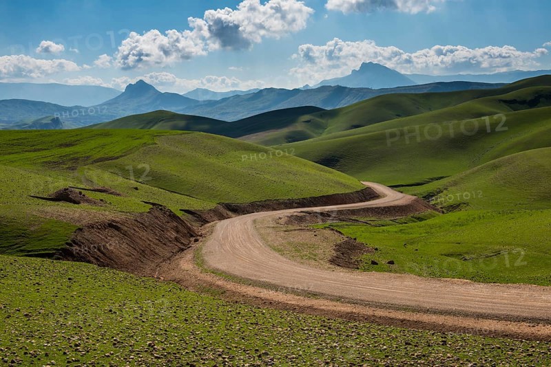 Road sneaking through the green hilly landscape