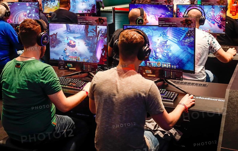 Visitors playing a computer game in front of screens