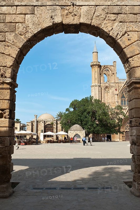 View through an archway towards a minaret and tower