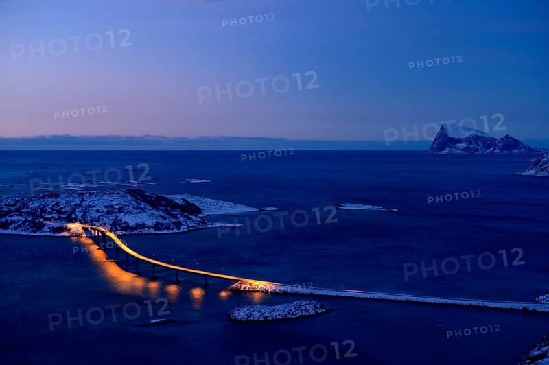 Fjord with a bridge in winter at sunset