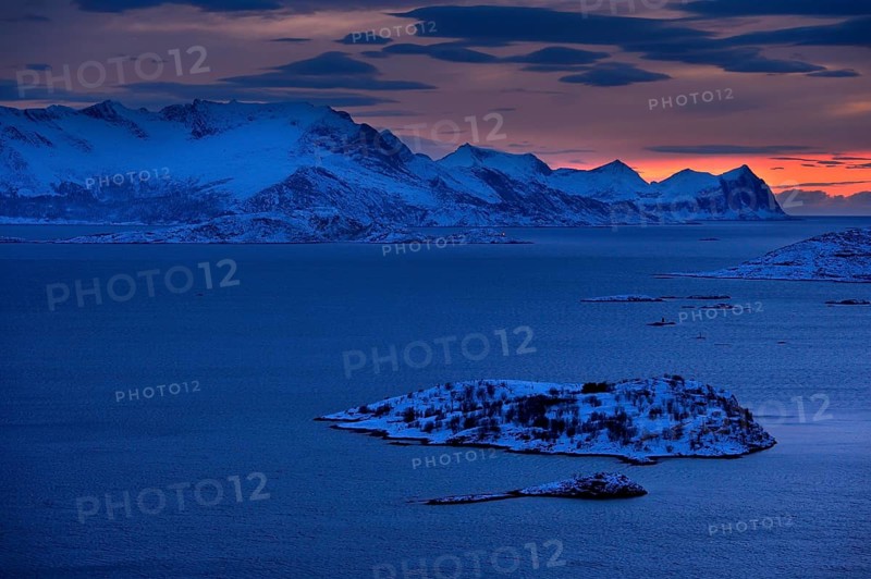 Fjord with mountains in winter at sunset