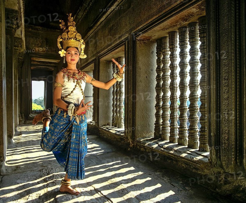 Temple dancer or apsara posing in front of the baluster windows in the temple of Angkor Wat