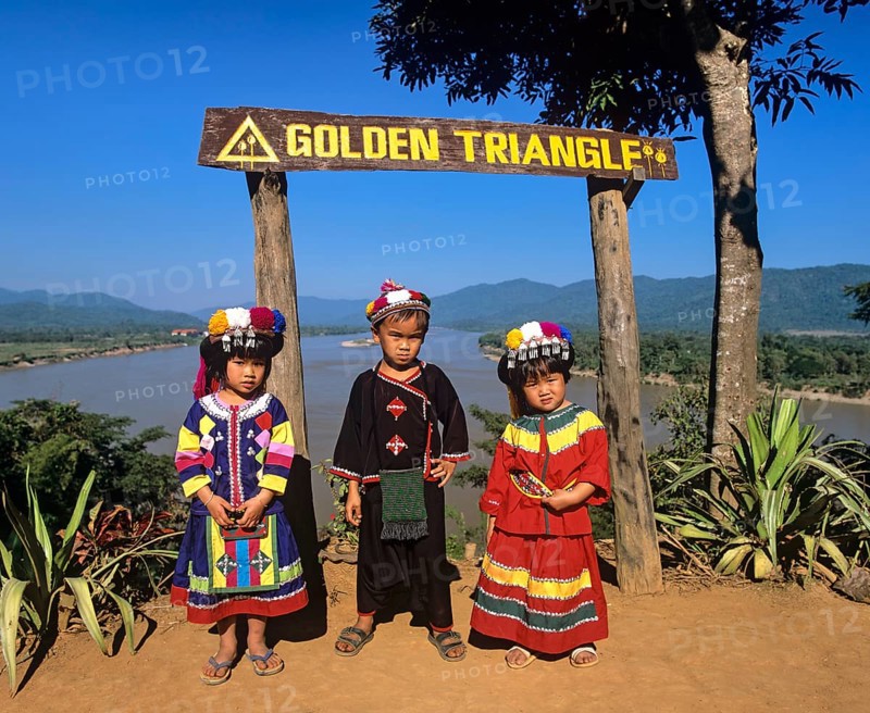 Hilltribe children before sign 'Golden Triangle'