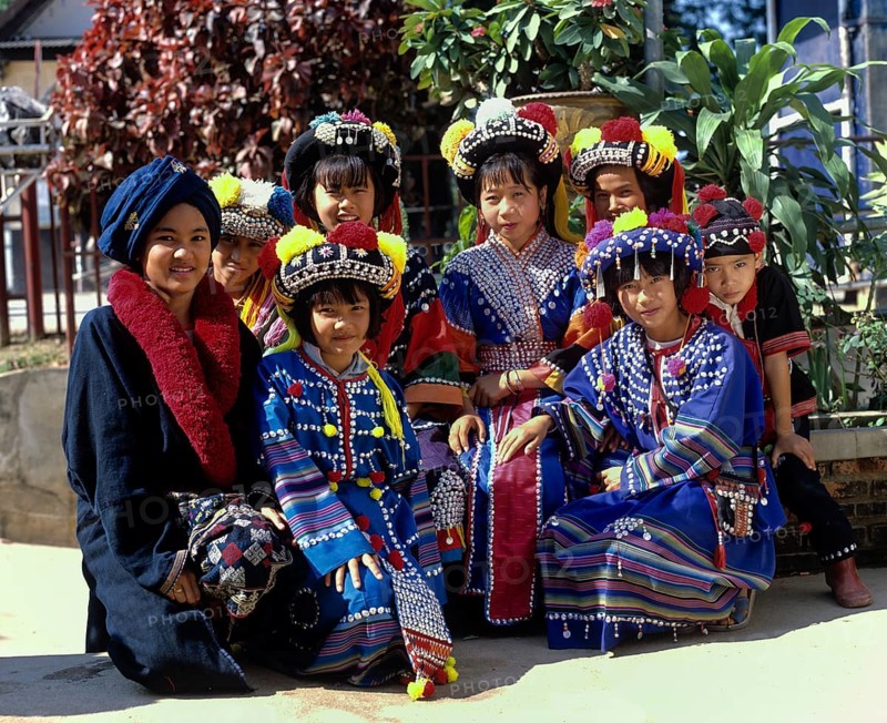 A group of children from the Lisu hill tribe wearing traditional costumes and headdresses