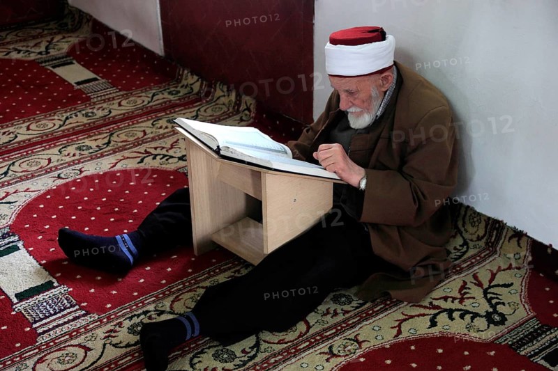 Muslim man studying the Quran in the Et'hem Bey Mosque