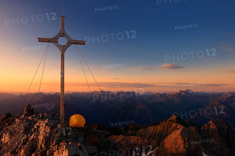 Summit cross with a tent on Grosser Krottenkopf Mountain at sunrise