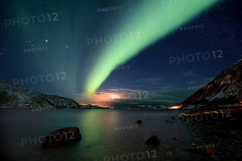 Northern Lights over fjord with winter landscape