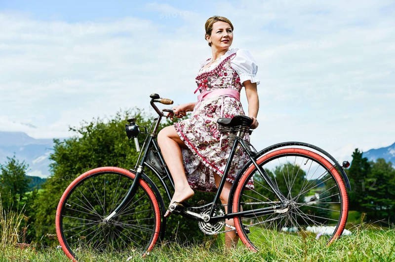 Woman wearing a dirndl on an old bicycle