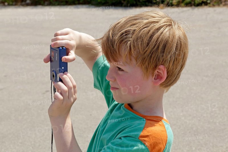 Young boy taking pictures