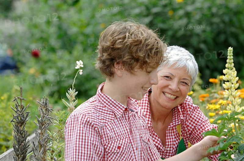 Grandmother and grandson are working together in the garden