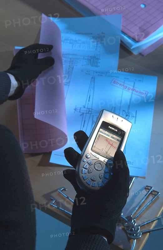 Burglar using a camera phone to take a photograph of secret plans