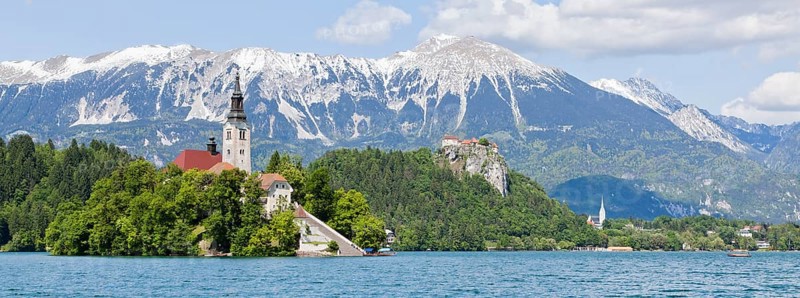 Blejski Otok Island with St. Mary's Church in Lake Bled and The Karawanks mountain range in Bled