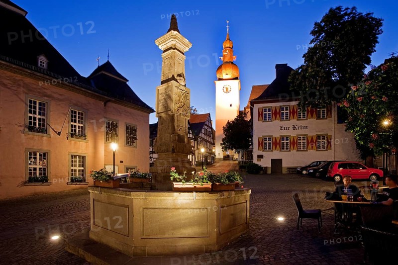 Maximilian Fountain in Alter Markt square with the old town hall and the bell tower at dusk