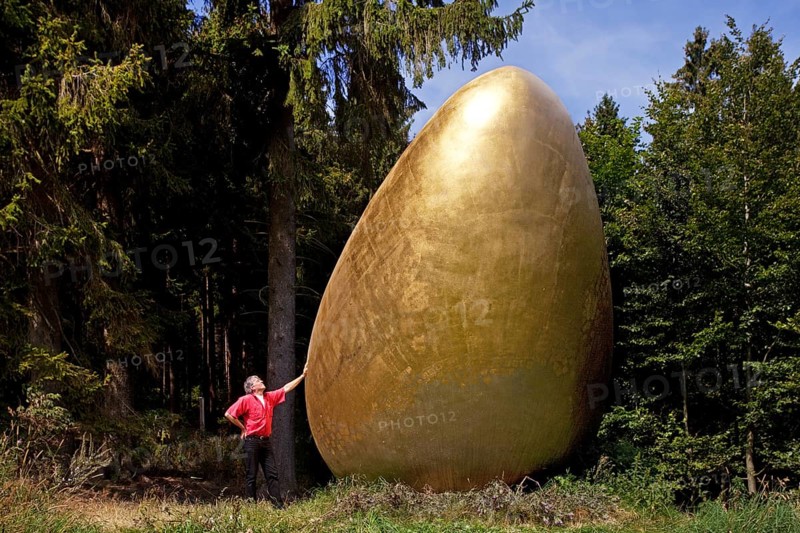 Man beside the sculpture 'What came first?' along the Waldskulpturenweg forest sculpture trail in Wittgenstein-Sauerland