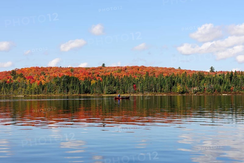 Canoe Lake with canoeists and a forest in autumn colours