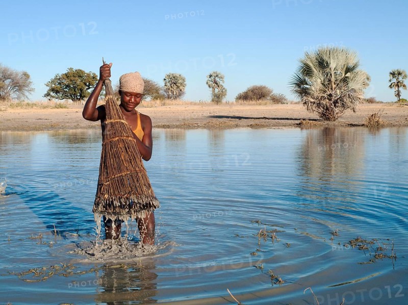 Ovambo girl fishing in a shallow pond