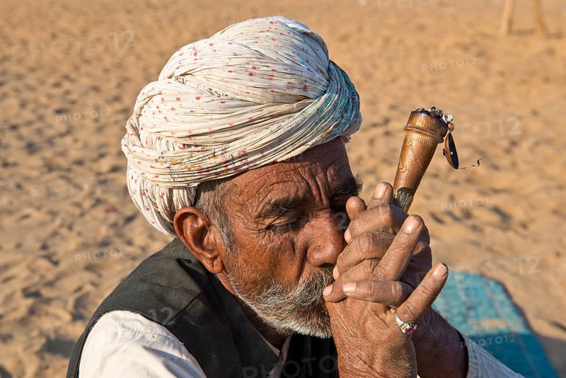 Indian man with a turban smoking a hash pipe
