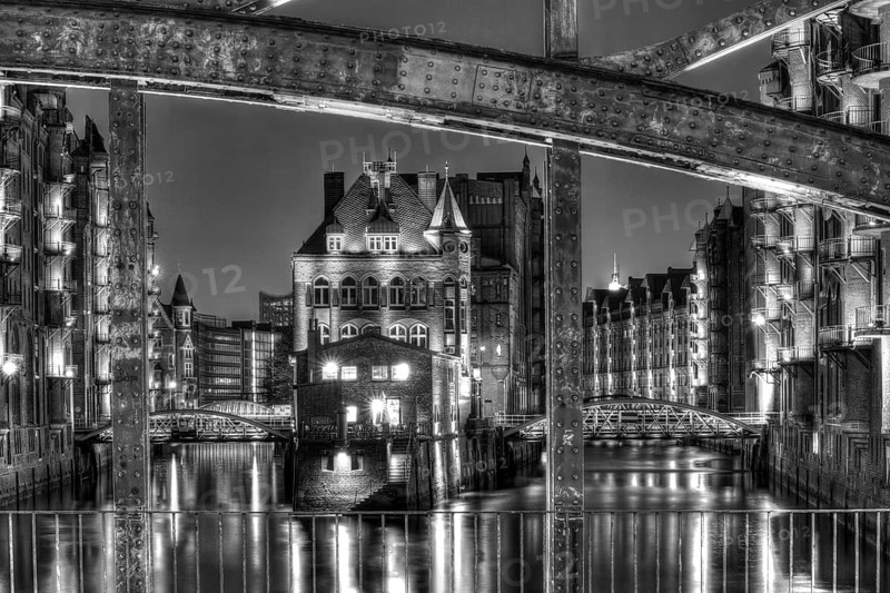 View through Poggenmuehlenbruecke bridge towards Wasserschloesschen water castle at night