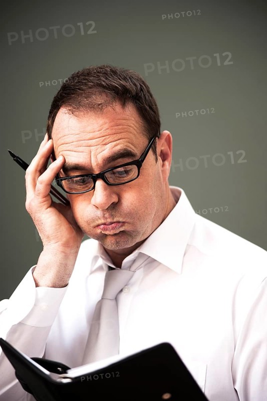 Businessman wearing glasses looking at his appointment calendar