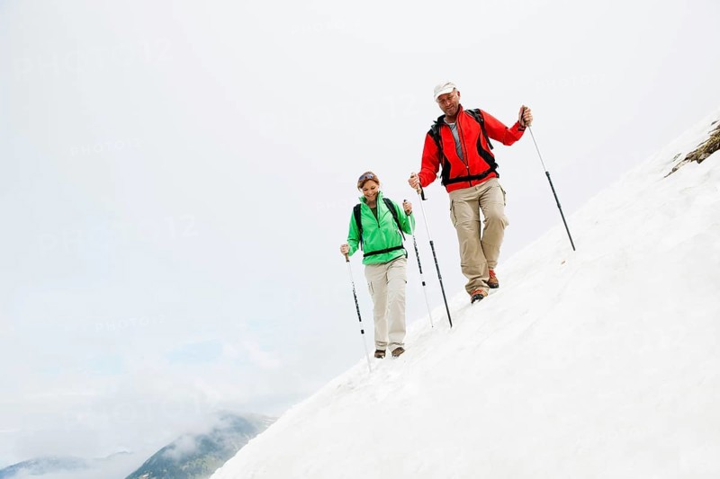 Couple moving over a snow field during their hike to Mt. Neunerkoepfle