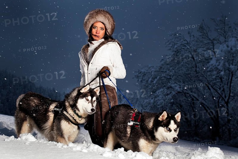 Young woman with huskies in the snow
