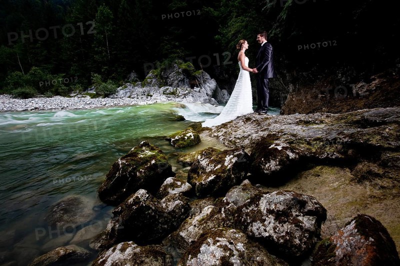 Bridal couple standing beside a torrent and looking lovingly at one another