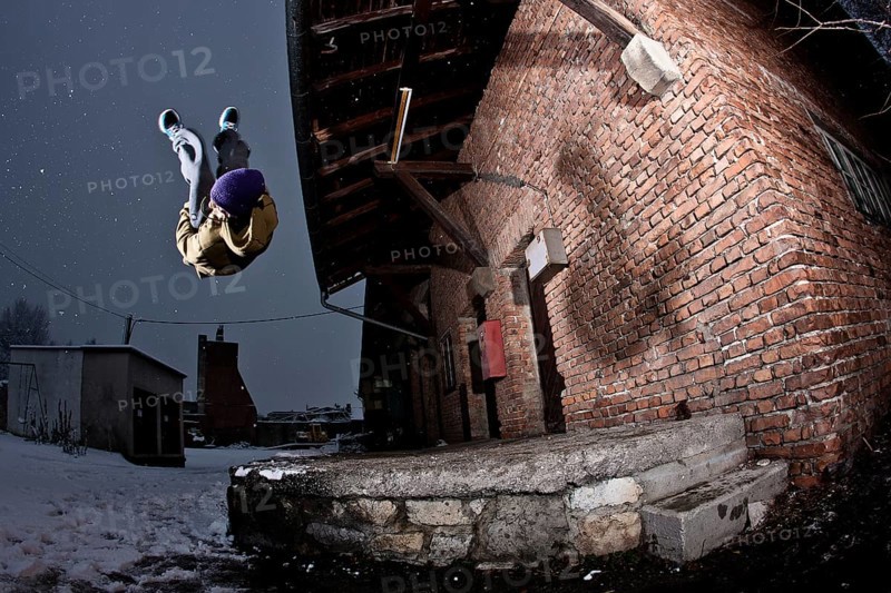 Freerunner doing a somersault at an old industrial site