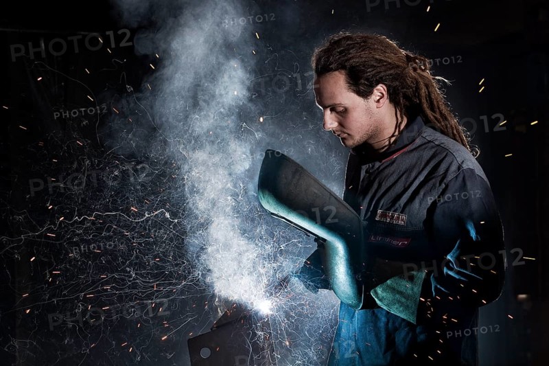 Welder welding with protective equipment