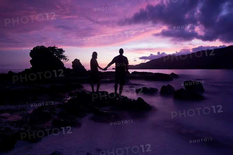 Couple standing on the beach after sunset
