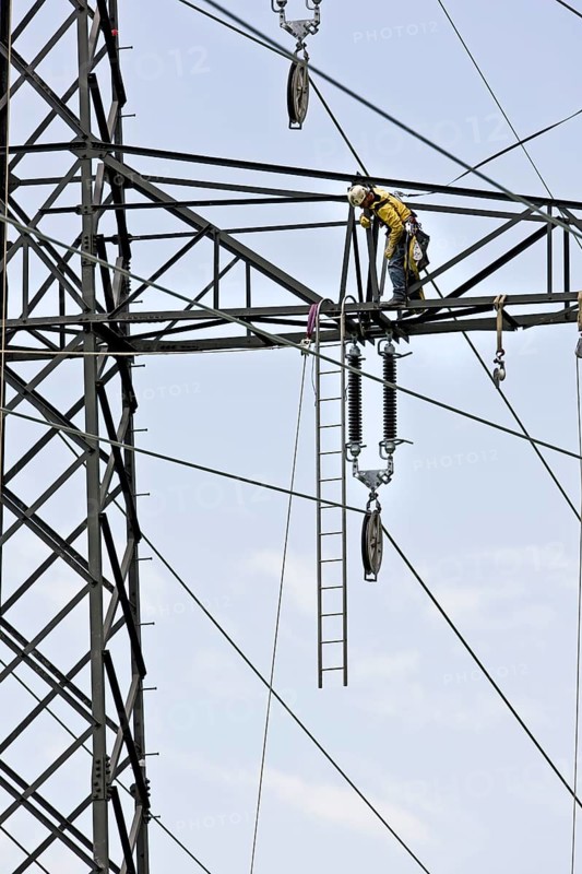 High voltage technician installing a new high-voltage power line