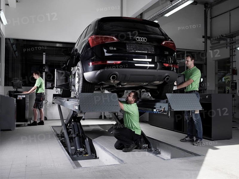 Workers assembling panels to track wheel alignments