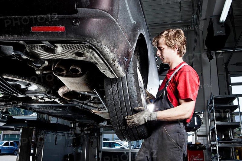 Car mechanic changing tyres in a car repair shop