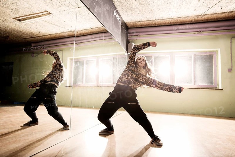 Breakdancer dancing in front of a mirror wall