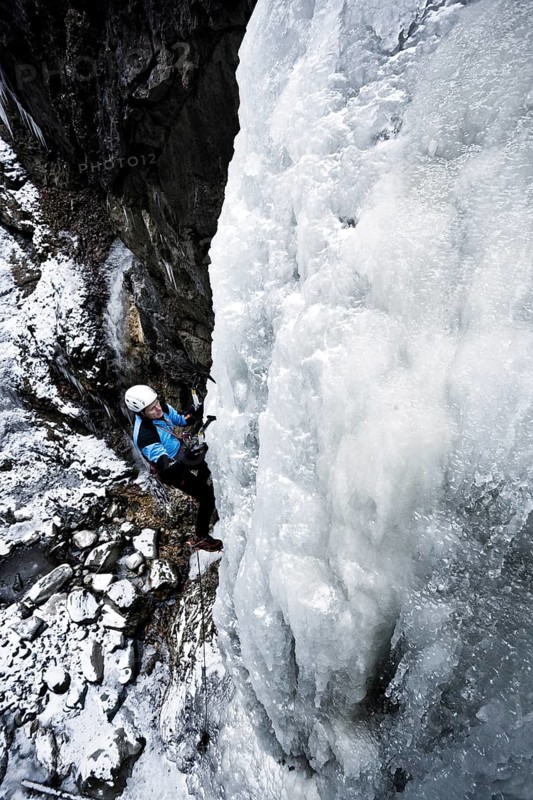 Ice climber climbing a frozen waterfall