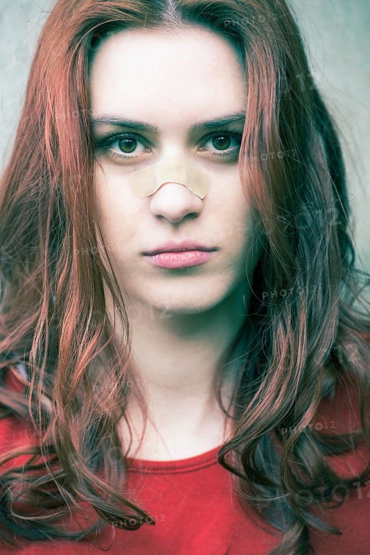 Portrait of a young woman with a band-aid on her nose