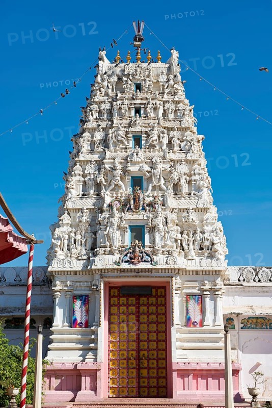 Depiction of gods and figures in white marble on a shikhara tower of a Hindu temple