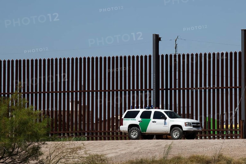 A Border Patrol vehicle at the border fence that separates the United States from Mexico