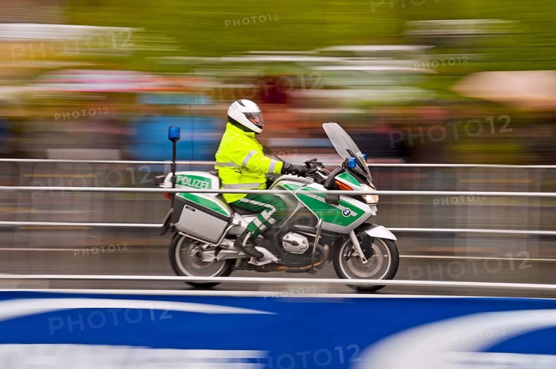 Accompanying motorcycle of the Rund um Koeln cycling race during rainy weather