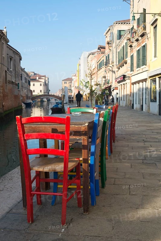 Colourful chairs of a street cafe on the Rio de la Misericordia