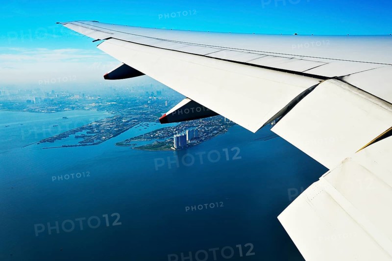 Wing of a plane and views of the port area of ??Jakarta on landing approach