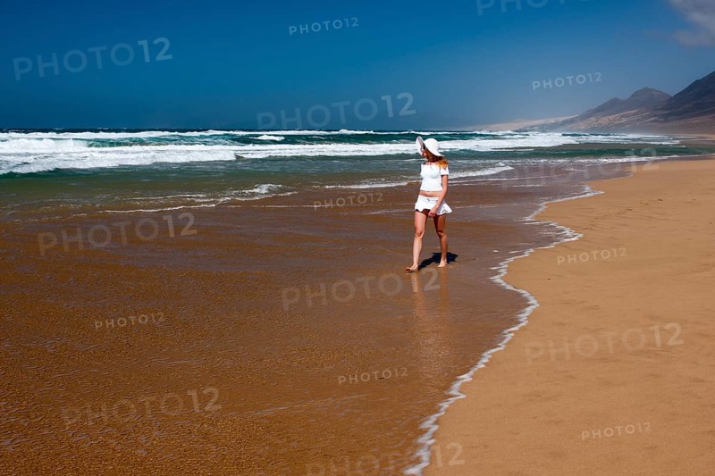 Woman walking along a sandy beach