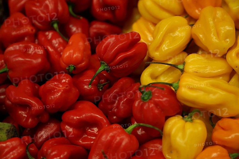 Red and yellow habanero chili peppers at a stand at Fruit Logistica