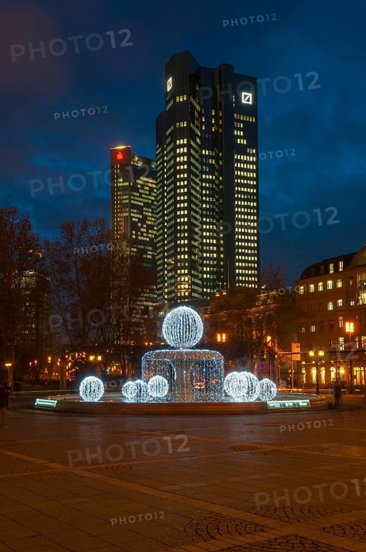 Illuminated Lucae Fountain on Opernplatz square in front of Trianon high-rise building and the Deutsche Bank Twin Towers