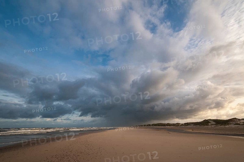 Dramatic cloud formation with rain showers over a North Sea beach