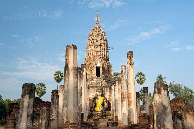 Seated Buddha statue in front of a chedi