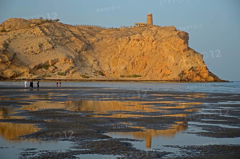 The rocky coast in Al Sawadi at the Gulf of Oman with a tower